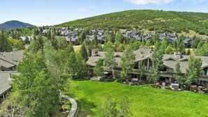 Un quartier résidentiel avec des maisons modernes, une pelouse bien entretenue et une montagne en arrière-plan.
