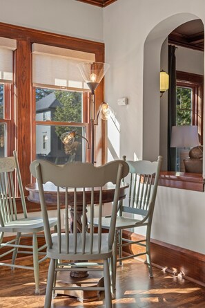 Un coin repas avec des chaises en bois, une table et une lampe.