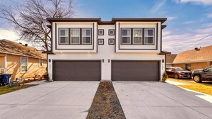 A two-story house with a garage, a driveway, and a small tree in the center. - 6BD Duplex, Modern, Lux, Free Park, Pool Table (Dallas)