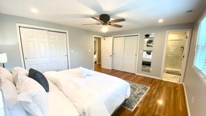 Ein Schlafzimmer mit Bett, Deckenventilator und begehbarem Kleiderschrank.
