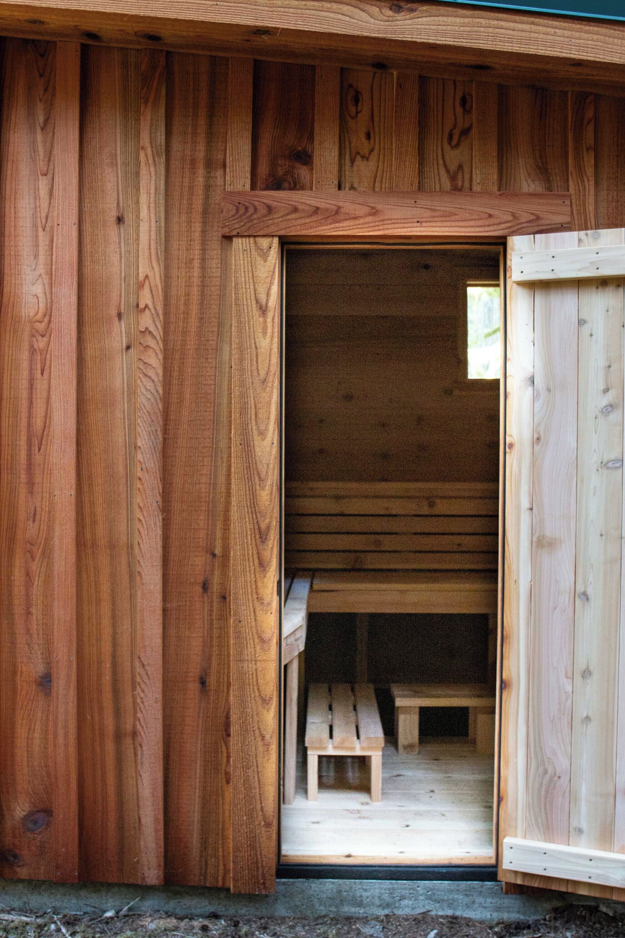 Une cabane en bois avec un banc à l’intérieur.