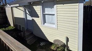 Una casita de una sola planta con puerta principal, ventana y puerta de garaje.