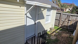 Una casa pequeña de una sola planta con porche delantero y entrada cubierta.