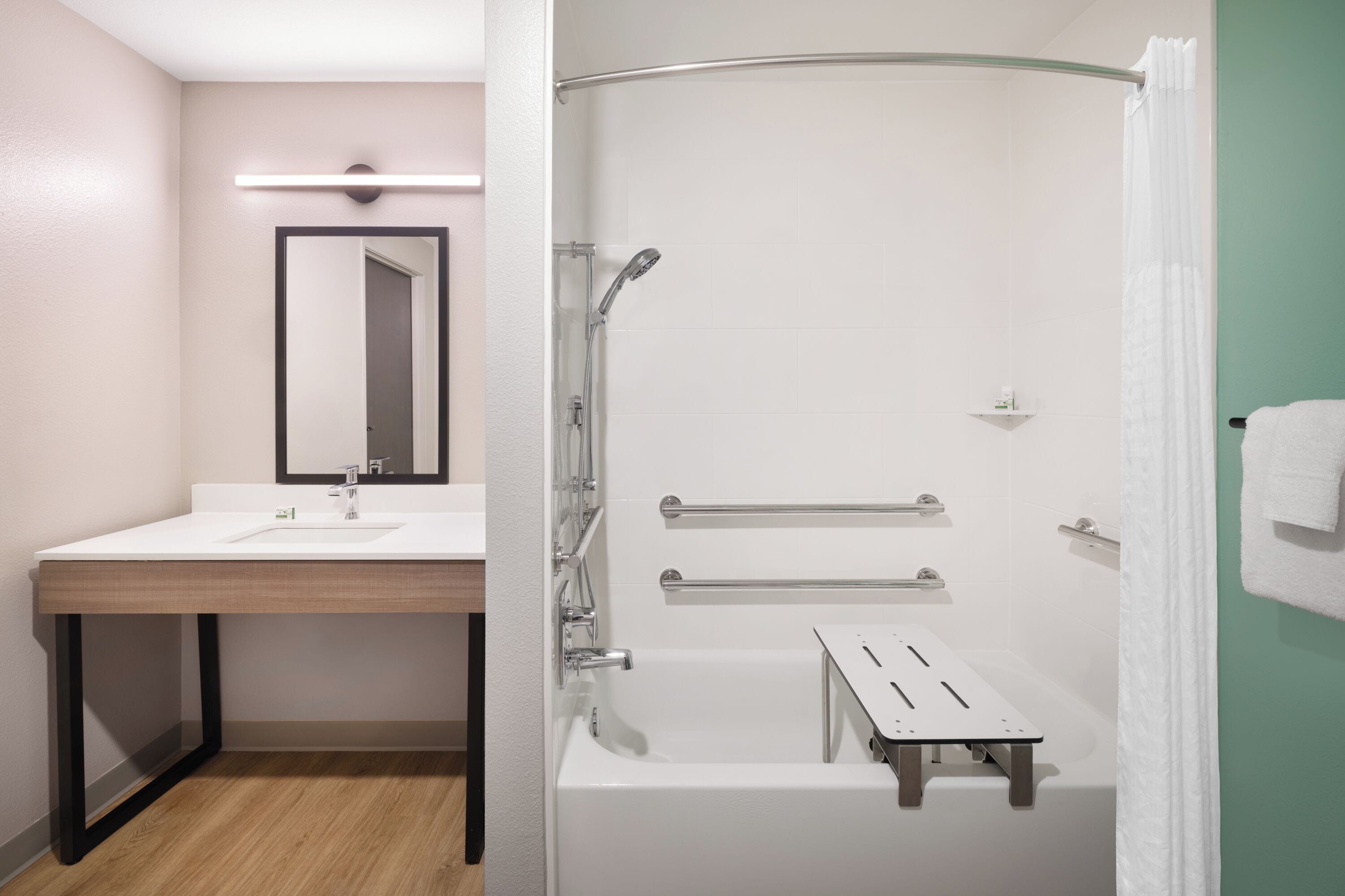 A bathroom with a sink, mirror, shower, and bathtub.