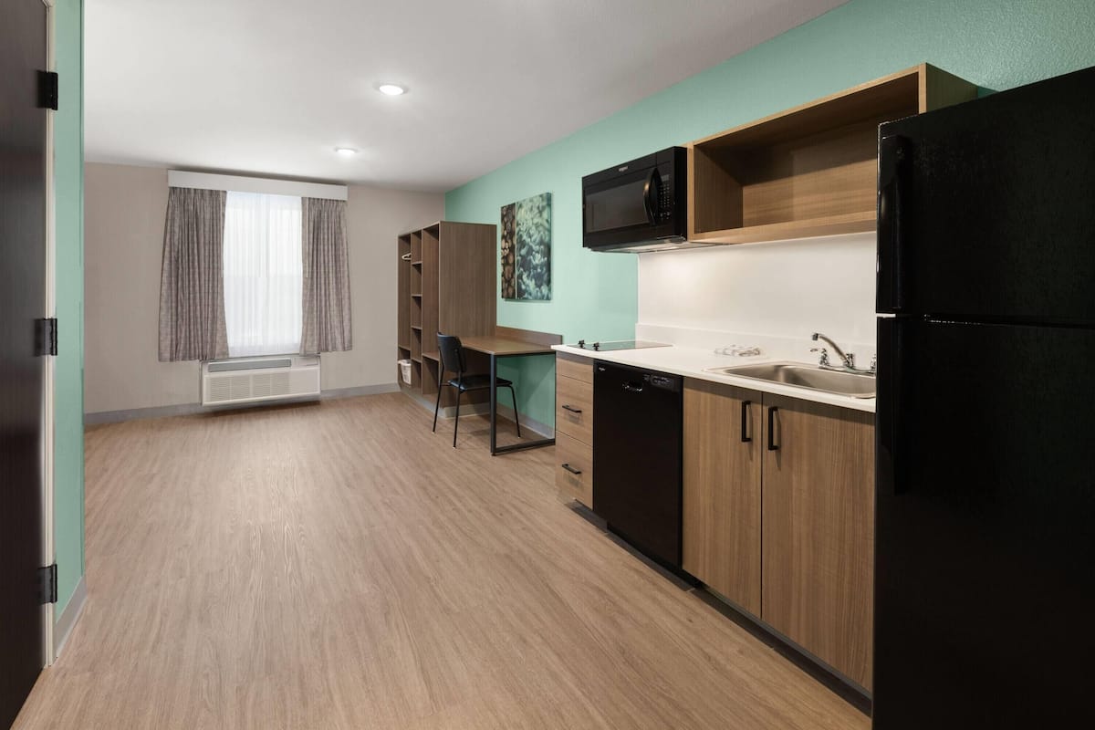 A modern kitchen with a microwave, sink, and black refrigerator.