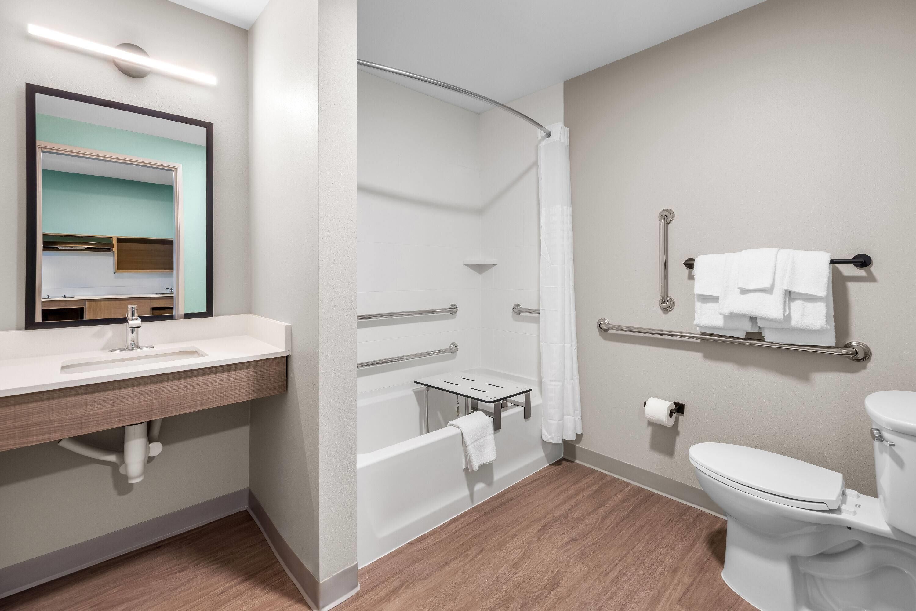 Une salle de bain moderne équipée d’un lavabo, de toilettes, d’une baignoire et d’une douche.