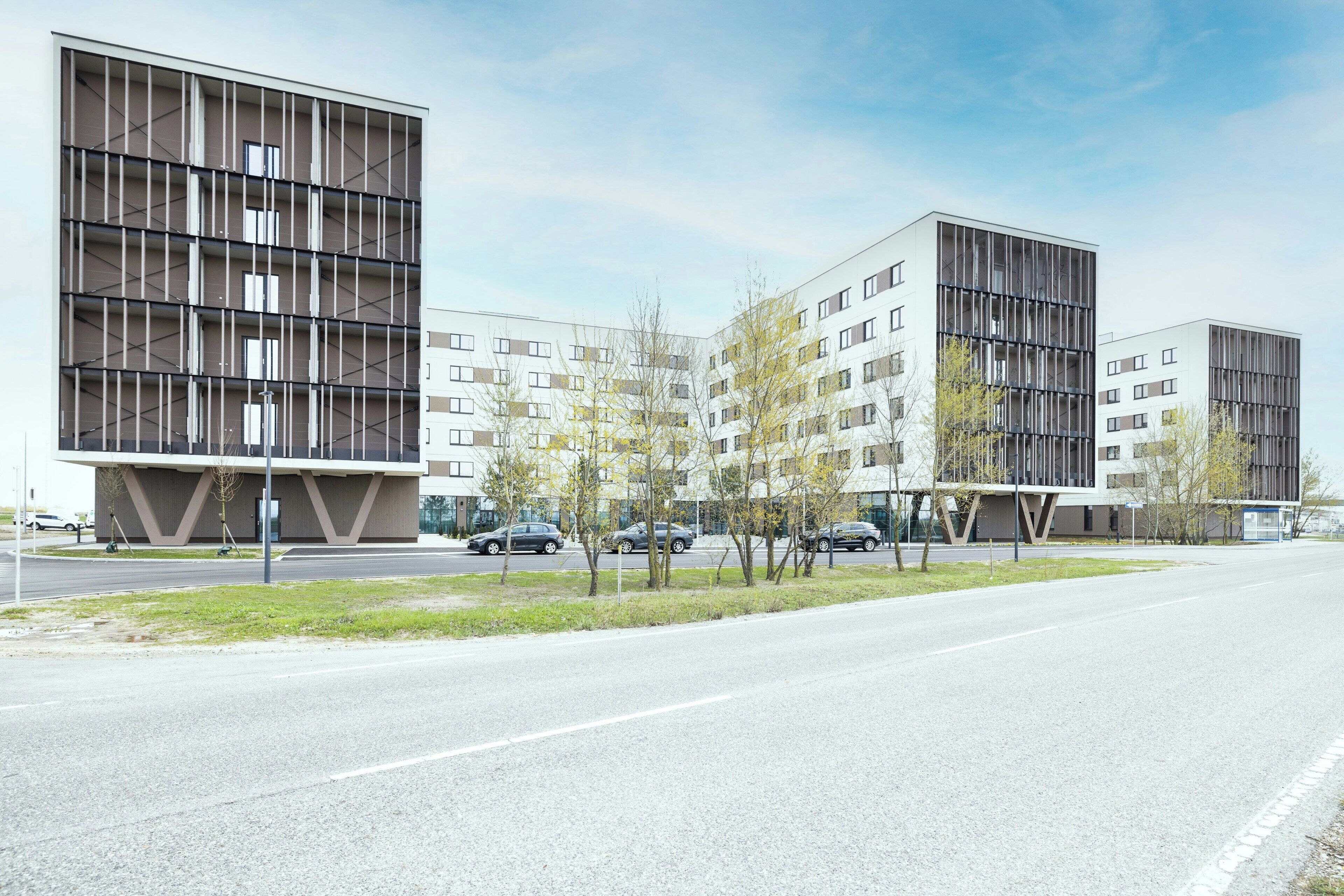 Ein modernes Gebäude mit mehreren Stockwerken, großen Fenstern und einem Flachdach.