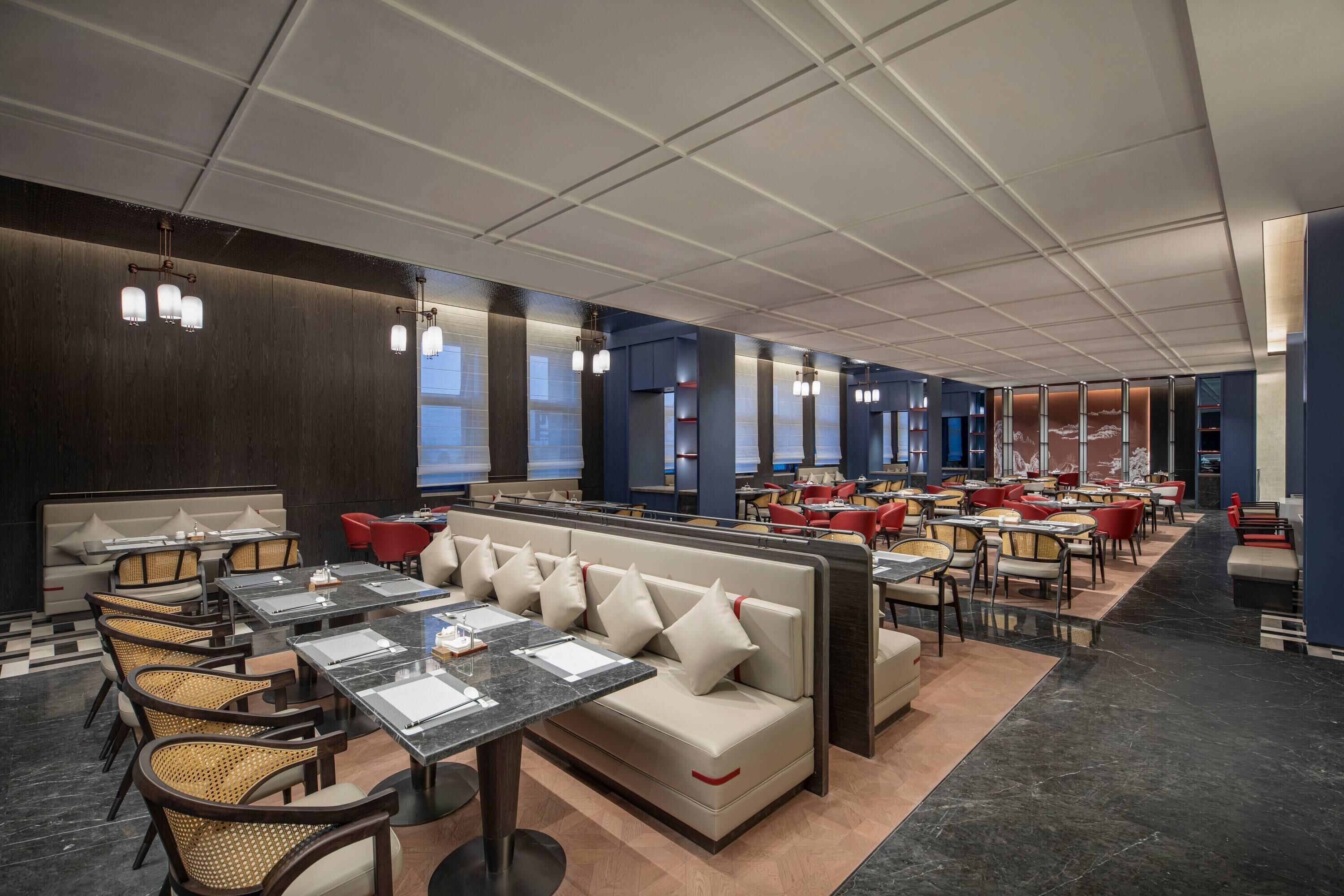 En moderne restaurant med høje borde, polstrede siddepladser og forskellige sidde muligheder.