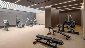 Un gimnasio moderno con cintas de correr, elípticas y equipamiento de levantamiento de pesas.