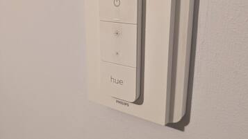 A Philips Hue light switch on a white wall.