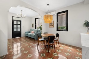 A dining area with a round table, chairs, and a hanging light fixture. - Casa Santurce: Boho-chic home with Rooftop Oasis (Rosario)