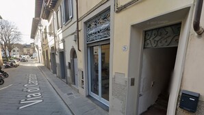 A street view with a building labeled "Via dei Cignoli" and a shop entrance with a metal gate. - Florence Slow-Life Flat in Oltrarno (Firenze)