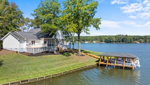 Ein Haus am See mit Steg und Boot.
