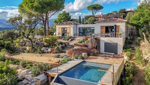 Een moderne villa met zwembad, terrasvormige tuin en uitzicht op zee.