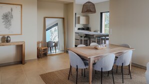 Een moderne keuken met een groot eiland, barstoelen en een hanglamp.