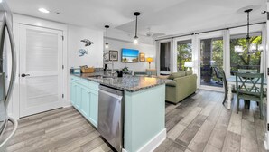 A modern kitchen with a central island, light blue cabinets, and stainless steel appliances. - 1 bed/2 bath, walk to Baytowne! Quick tram ride to beach! (Miramar Beach)