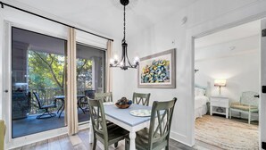 A dining area with a table and chairs, a chandelier, and a painting on the wall. - 1 bed/2 bath, walk to Baytowne! Quick tram ride to beach! (Miramar Beach)