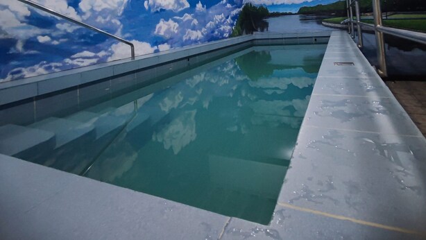 An indoor swimming pool with a mural of a blue sky and clouds on the ceiling. - Modern Oasis - Cozy Loft Condo in Manila (Manila)