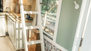 Een keuken met een houten ladder, een radiator en uitzicht op de omgeving.