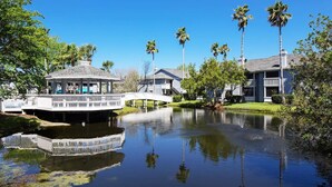 A serene lakeside setting with a bridge, a gazebo, and residential buildings. - 1st Floor, Free PPV, Near Mayo Clinic, Pool, BBQ, (ponte vedra beach)