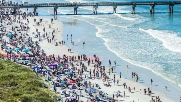A crowded beach with a pier extending into the water. - 1st Floor, Free PPV, Near Mayo Clinic, Pool, BBQ, (ponte vedra beach)