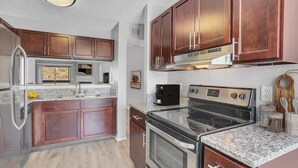 A modern kitchen with dark wood cabinets, stainless steel appliances, and granite countertops. - 1st Floor, Free PPV, Near Mayo Clinic, Pool, BBQ, (ponte vedra beach)