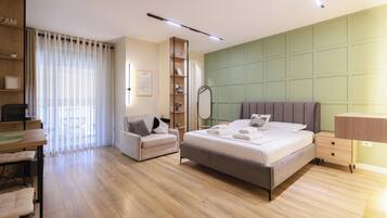 Ein modernes Schlafzimmer mit einem großen Bett, einer Couch, einem Schreibtisch und einem Bücherregal.
