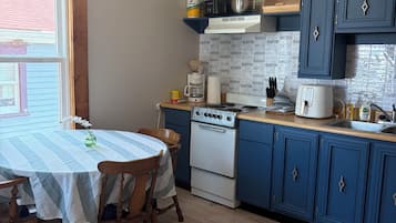 Uma cozinha com fogão, forno e armários azuis.