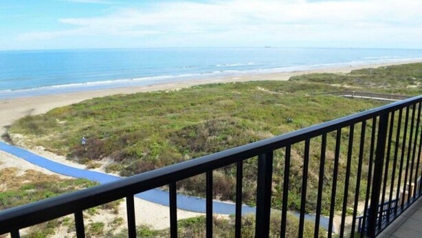 Ein Balkon mit Blick auf Strand und Meer.