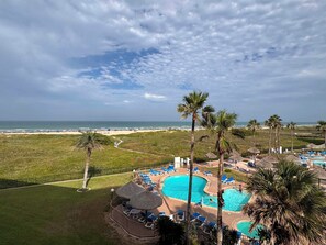 A resort with a swimming pool, lounge chairs, and a view of the beach. - Three Bedroom Two Bath Beachfront Condo (South Padre Island)