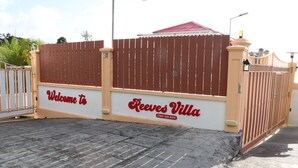 Ein begrenzter Eingangsbereich mit einem Schild, das 'Welcome to Reeves Villa' und eine Kontaktnummer zeigt.