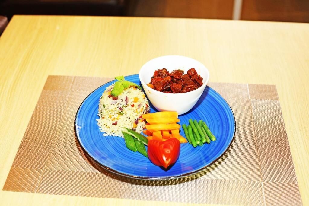 Une assiette de riz, de légumes et un bol de viande.