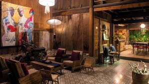 Un intérieur chaleureux avec des murs en bois, un sol carrelé et un coin repas comprenant des tables et des chaises.