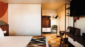 Une chambre d’hôtel comprenant un lit, un bureau, une chaise, une armoire et un téléviseur.