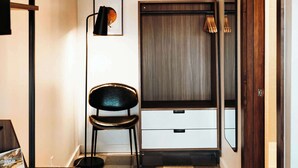 A compact room with a checkered floor, a desk with a chair, a wardrobe, and a mirror. - High Desert Hangout | La Vista Motel | 109 (Denver)