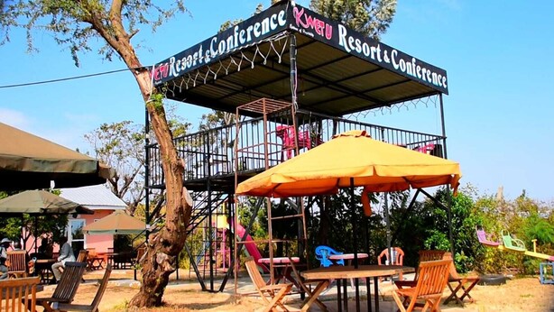 A covered outdoor seating area with a sign for Kwet U Resort & Conference. - kuwetu resort and conference (Muthara)