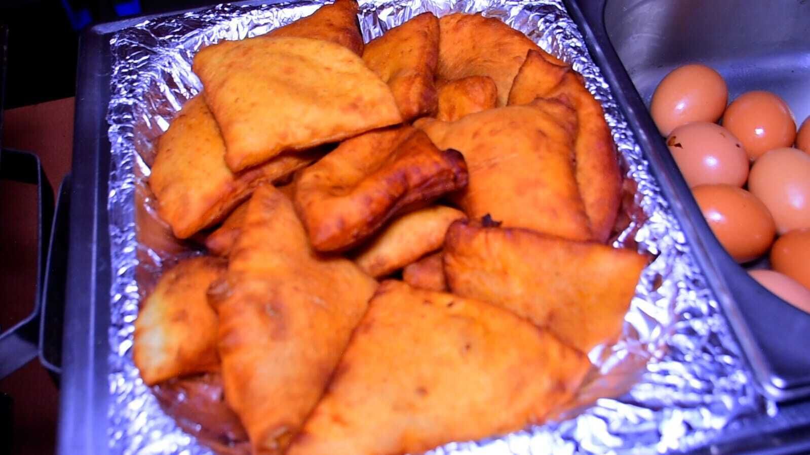 A tray of fried pastries and a container of eggs.