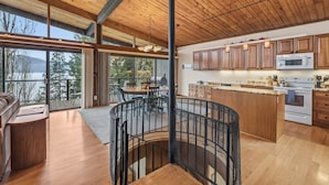 Une cuisine spacieuse avec des meubles en bois, un îlot central et une vue sur l’extérieur.