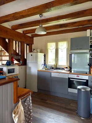 A kitchen with wooden beams, a white refrigerator, a microwave, a sink, and a stove. - House 5 rooms 8  people with garden 800 m from the beach (SARZEAU)