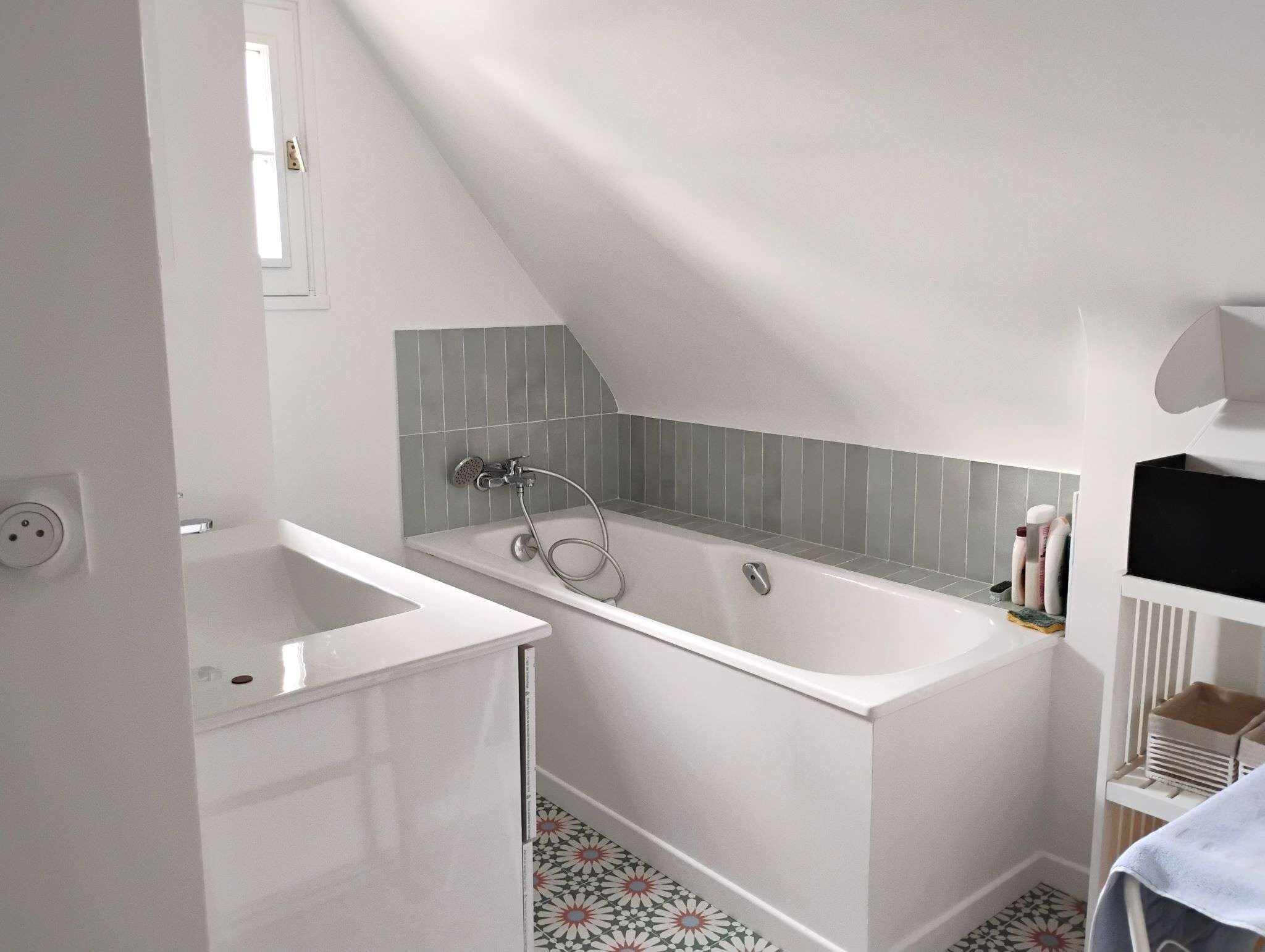 Ein modernes Badezimmer mit einer freistehenden Badewanne, einem weißen Waschbecken und einer gefliesten Duschfläche.