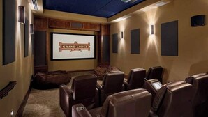 A home theater room with a starry ceiling, a large screen displaying "Grand Lodge," and leather recliners. - Quaint 3-bedroom condo in Breckenridge perfect for your getaway (Breckenridge)