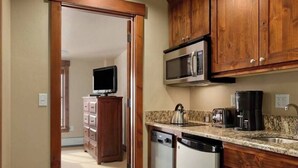 A compact kitchen with wooden cabinets, a microwave, a toaster, a kettle, and a dishwasher. - Quaint 3-bedroom condo in Breckenridge perfect for your getaway (Breckenridge)