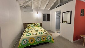Une chambre à coucher avec un lit, une fenêtre, une douche et un miroir au mur.