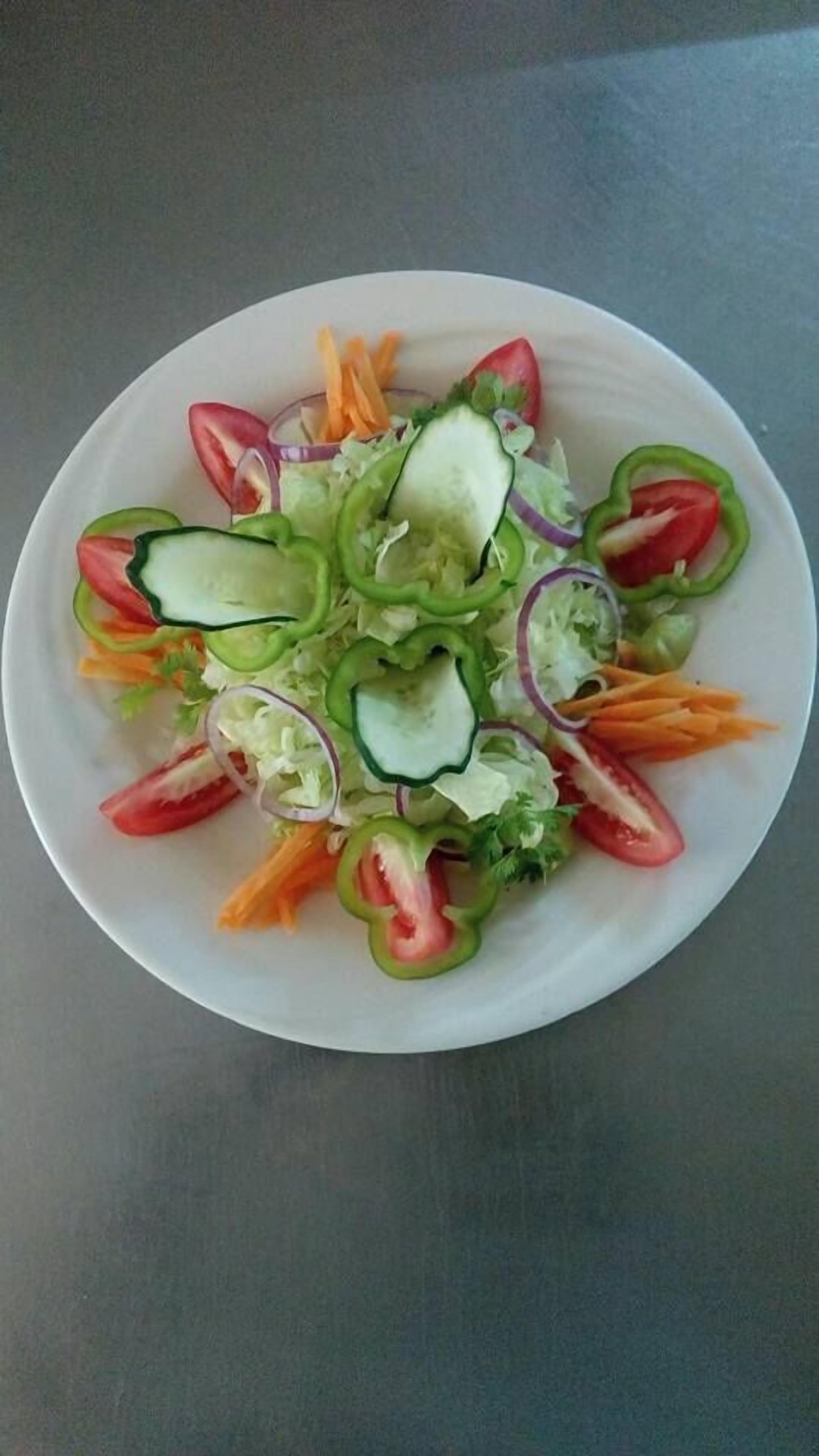 Een bord met een salade en diverse groenten.