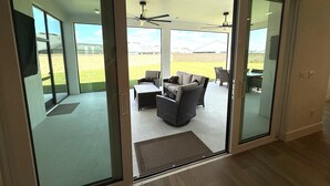 Un interior moderno con un divisor de vidrio corredera que da a un patio exterior.