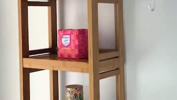 A wooden shelf unit with folded towels, a decorative box, and a canister.