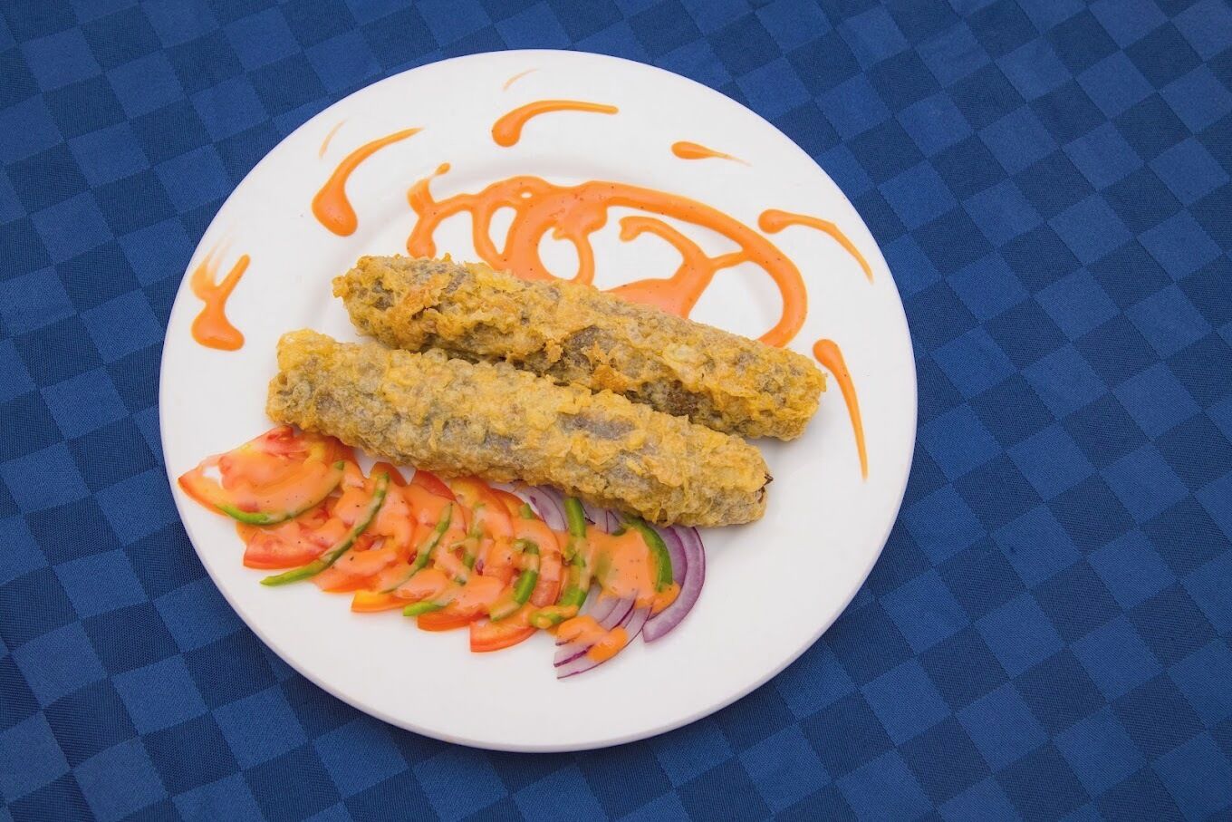 Un plato con dos alimentos fritos y una ensalada de verduras.