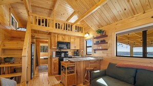 L’intérieur d’une cabane comprend une cuisine, un coin repas et un salon confortable.