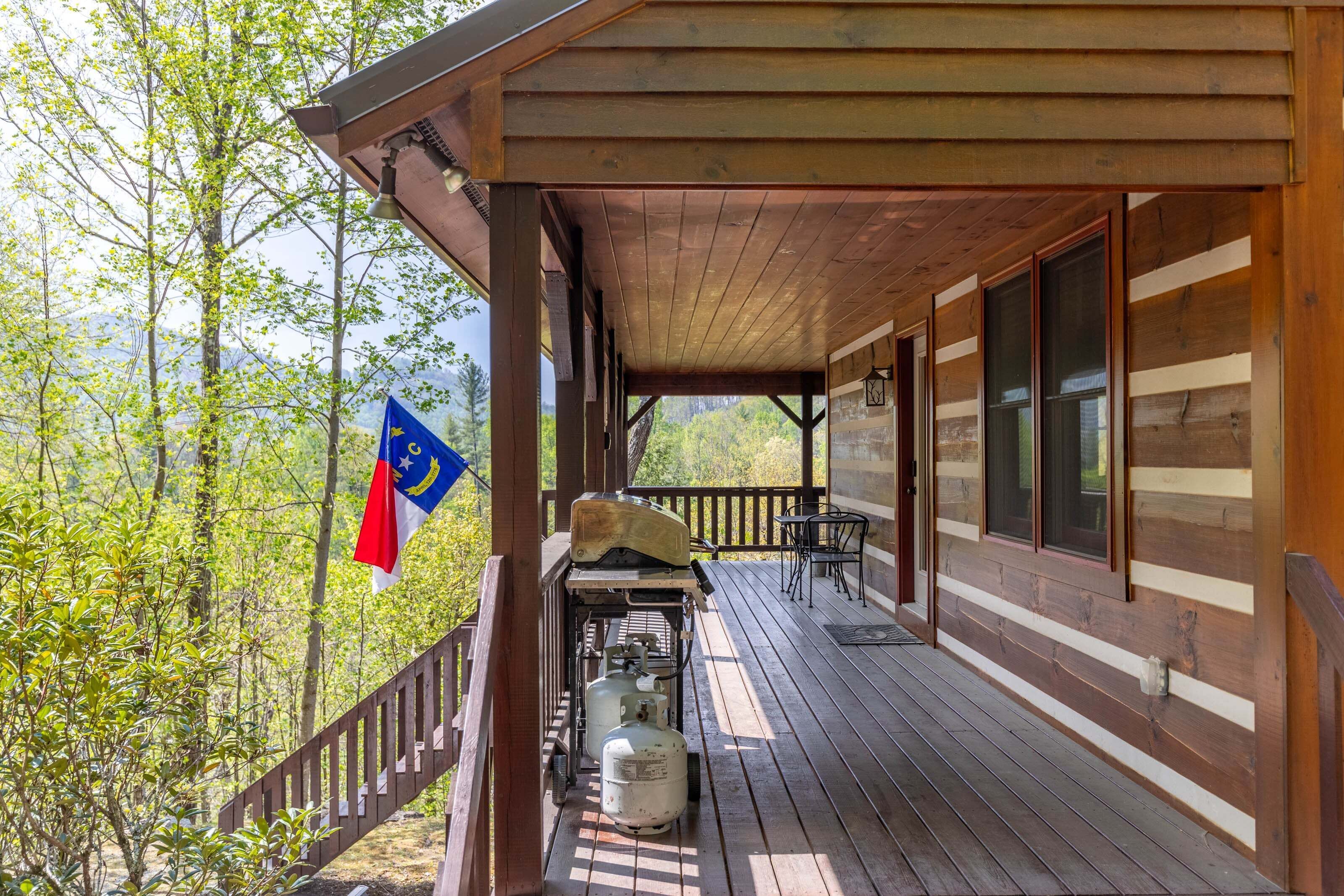 A wooden deck with a covered area, a flag, and a grill.