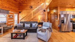 L’intérieur d’une cabane en rondins comprend un escalier, un salon et une cuisine.
